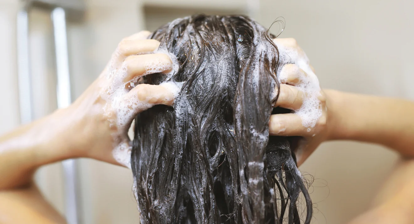 Frau wäscht sich die Haare – sanfte Reinigung bei juckender Kopfhaut