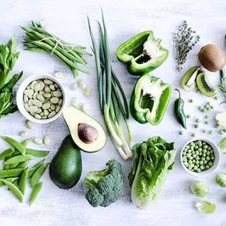 Spätakne Auswahl an grünen Gemüsesorten und Obst auf hellem Untergrund – symbolisch für hautfreundliche Ernährung bei Spätakne.