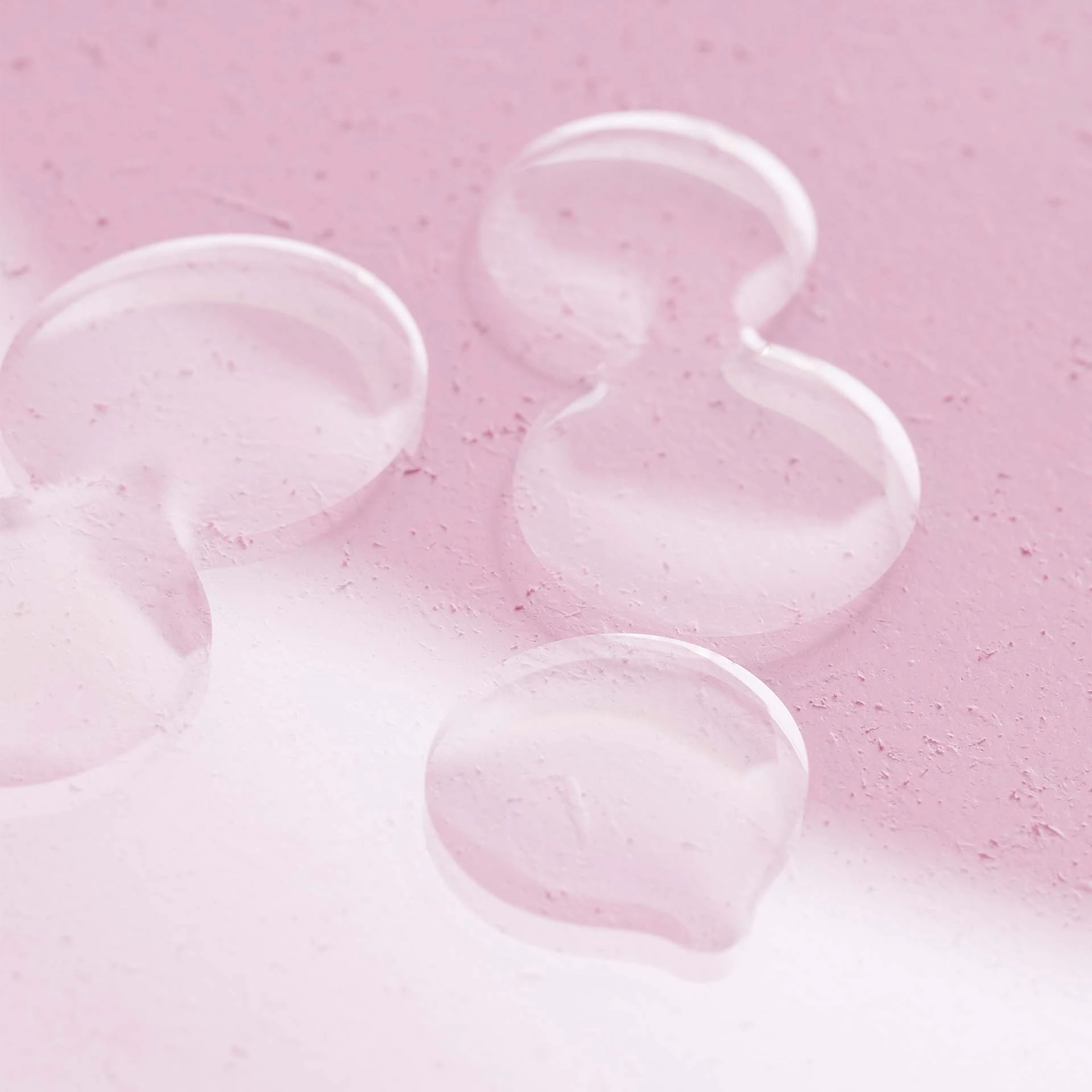 Klarer, farbloser Gel-Tropfen auf rosa strukturierter Oberfläche, Nahaufnahme der Textur