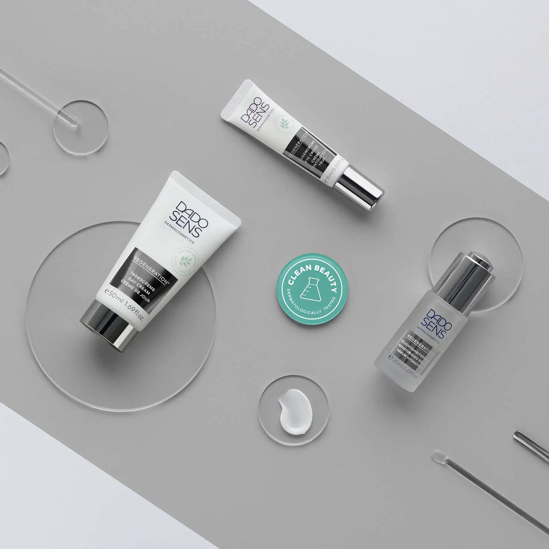 DADO SENS Regeneration Tagescreme, Augencreme und Feuchtigkeitsserum auf grauem Untergrund mit Clean Beauty Siegel