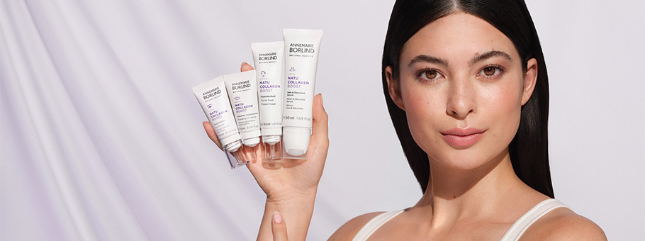 Frau hält vier ANNEMARIE BÖRLIND NATUCOLLAGEN BOOST Pflegeprodukte vor hellem Hintergrund