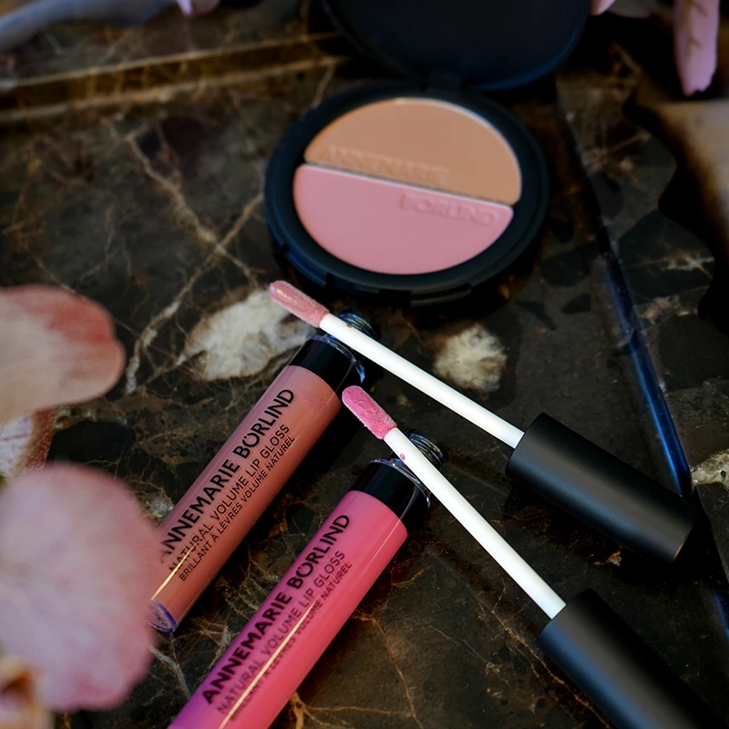 ANNEMARIE BÖRLIND 2in1 Bronzer & Blush und Natural Volume Lip Gloss in herbstlichen Farbtönen für den Make-up Look „A Hug of Colour“ auf Marmoroberfläche inszeniert