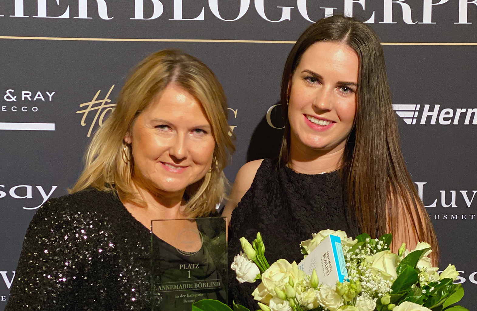 Zwei Frauen bei Preisverleihung, eine hält ANNEMARIE BÖRLIND Trophäe, die andere Blumenstrauß mit Produktbox