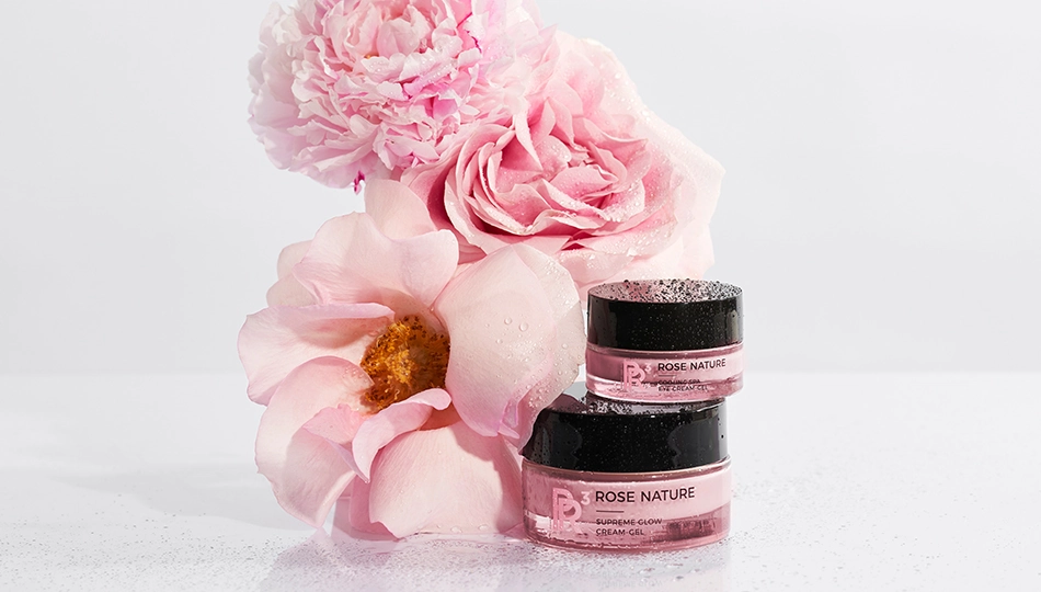 Rosen-Kosmetik-Produkte von ANNEMARIE BÖRLIND und Pfingstrosen inszeniert vor weißem Hintergrund. 