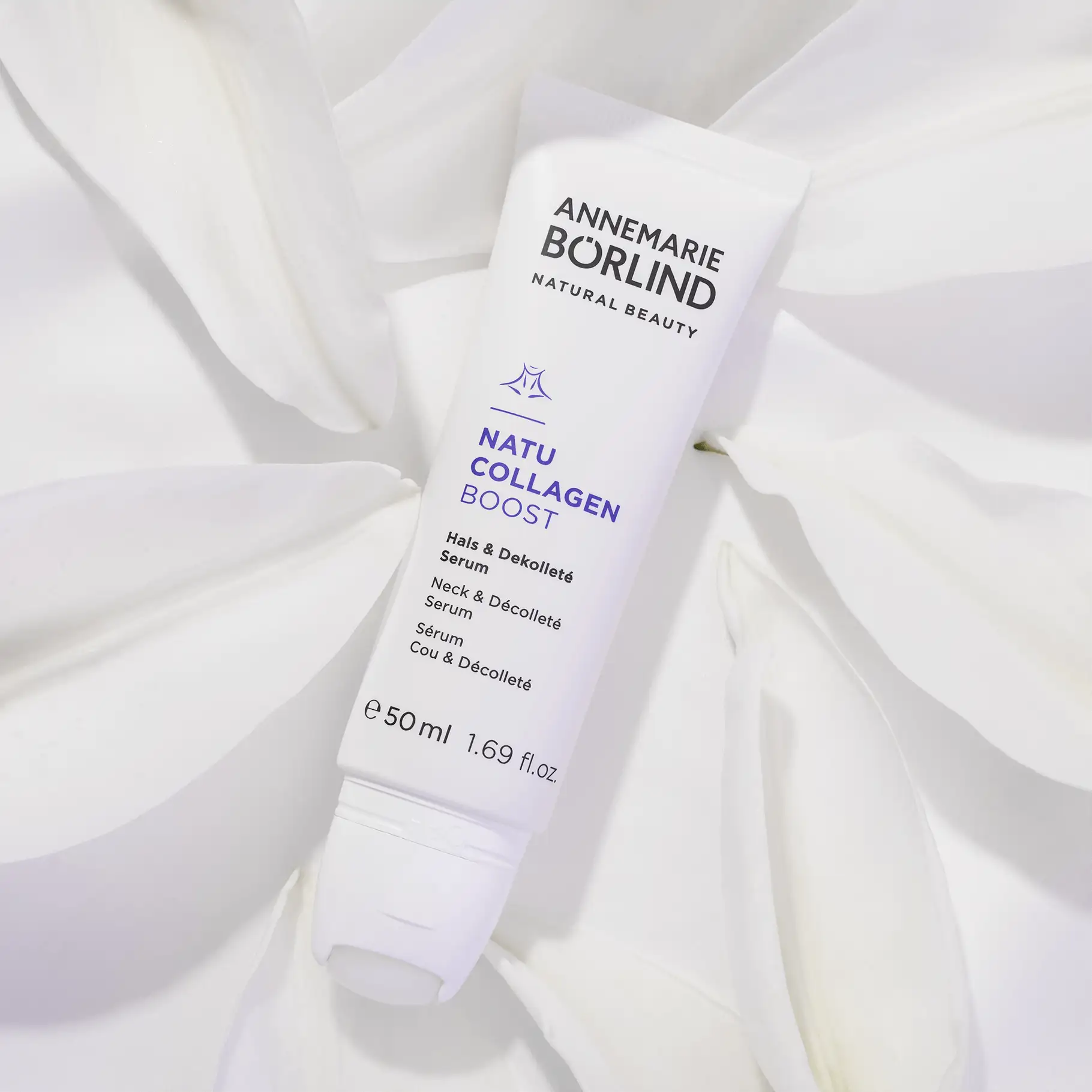 ANNEMARIE BÖRLIND NATU COLLAGEN BOOST Serum für Hals und Dekolleté, 50 ml vor weißen Blütenblättern