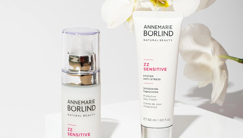 Was ist Naturkosmetik: ANNEMARIE BÖRLIND ZZ SENSITIVE Tagespflege-Produkte, inszeniert mit weißen Orchideen als Symbol für sanfte, natürliche Hautpflege.