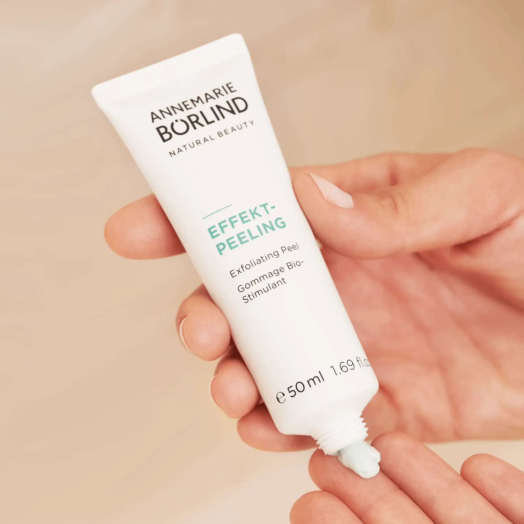 ANNE MARIE BÖRLIND Effekt-Peeling in weißer Tube mit grünem Peeling-Inhalt auf Finger aufgetragen