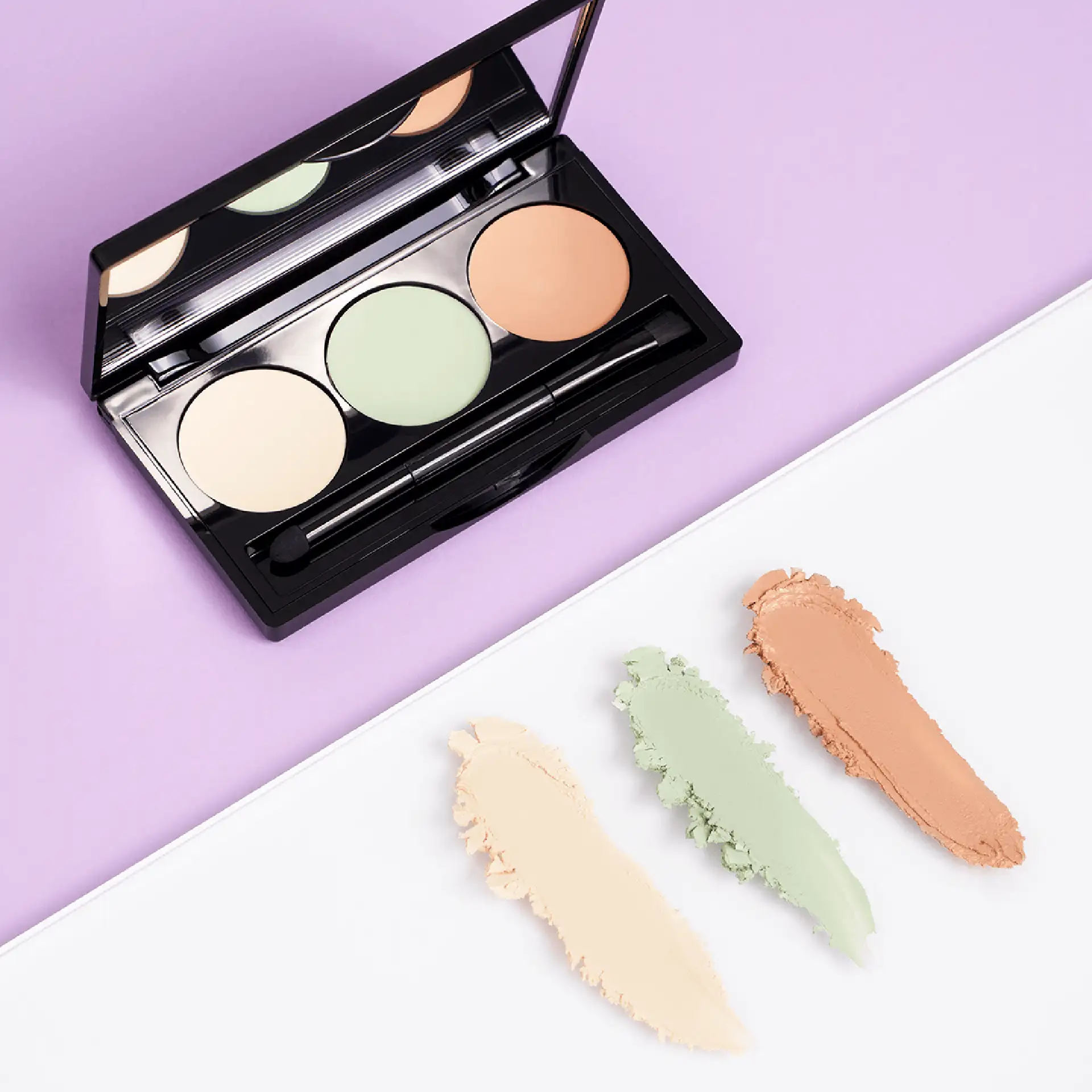 DADO SENS Hypersensitive Concealer Palette mit drei Farbnuancen und integriertem Spiegel auf lila Hintergrund