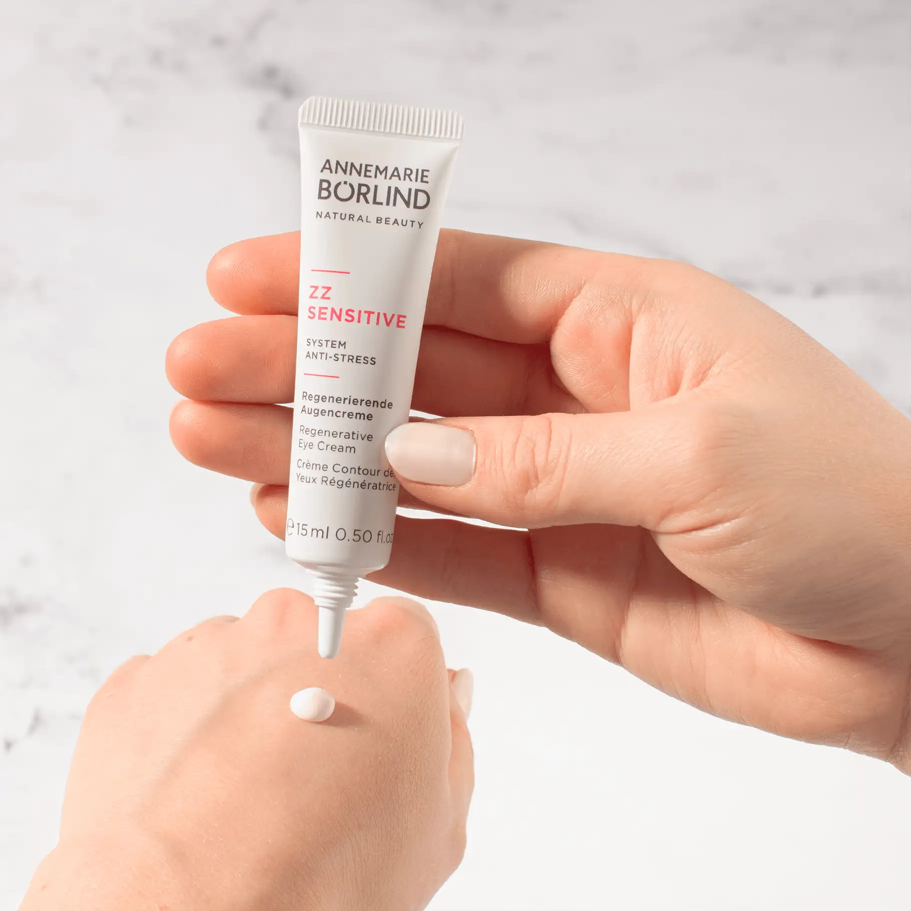 ANNEMARIE BÖRLIND ZZ SENSITIVE regenerierende Augencreme in Hand mit Creme-Tropfen auf Haut