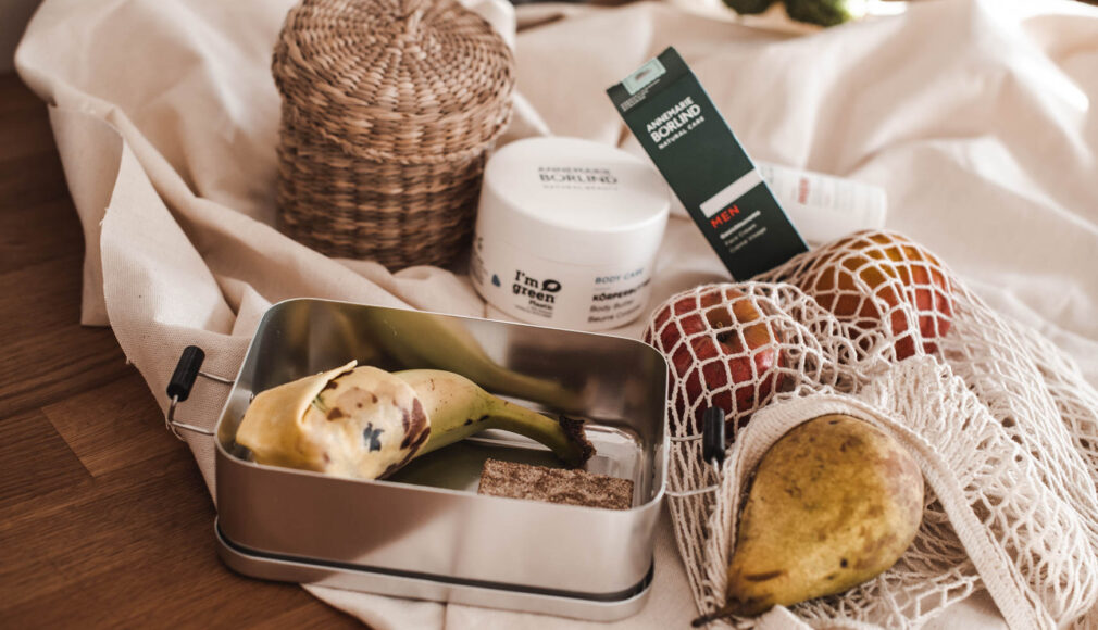 Metallbrotdose mit Bananenschale und Knäckebrot, Netzbeutel mit Obst, ANNEMARIE BÖRLIND Pflegeprodukte