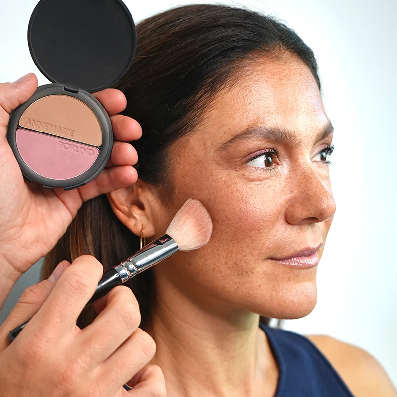 Make-up Artist Kevin Bete trägt den Bronzer aus dem ANNEMARIE BÖRLIND 2in1 Bronzer & Blush für den Herbst Make-up Look „A Hug of Colour“ auf