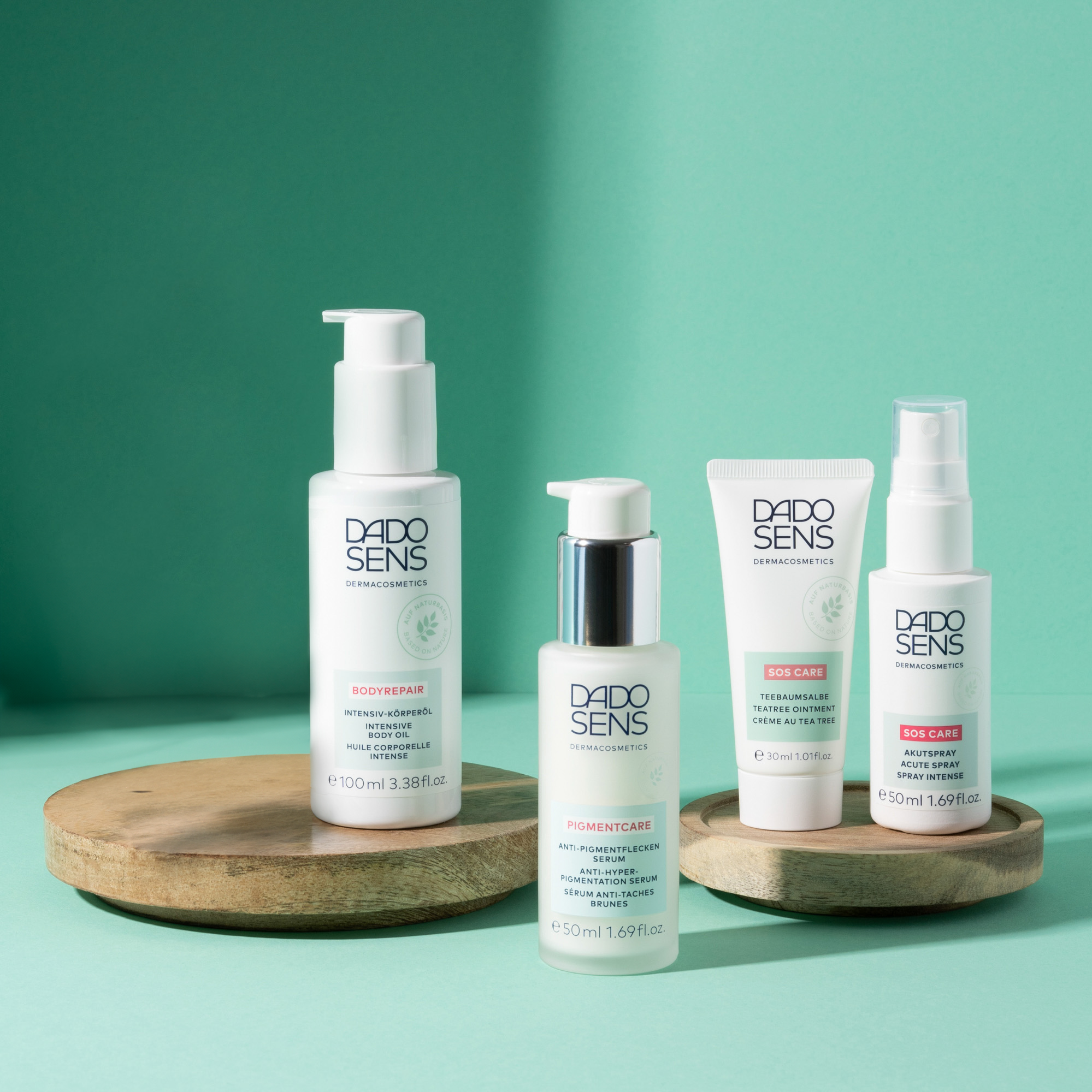 DADO SENS Spezialpflege mit Intensiv-Körperöl, Anti-Pigmentflecken-Serum, Teebaumsalbe und Akutspray auf Holzplatten