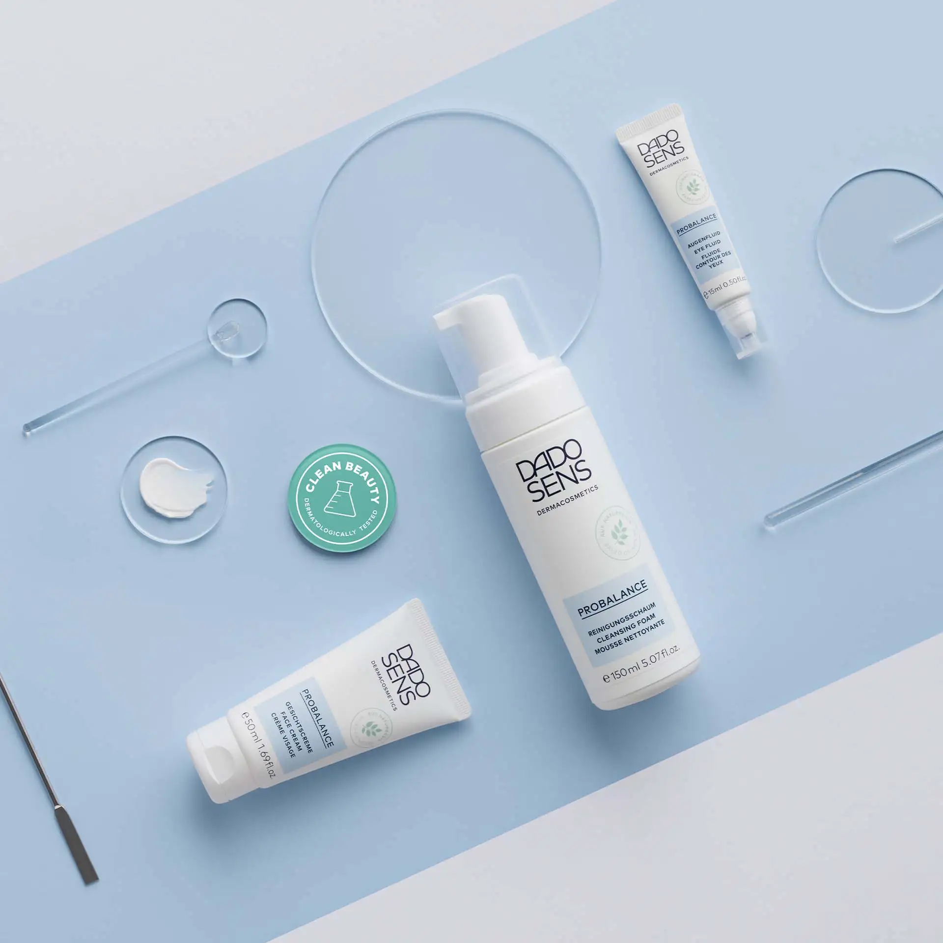 DADO SENS PROBALANCE Reinigungsschaum, Gesichtscreme und Augenfluid auf blauem Hintergrund mit Cremeprobe