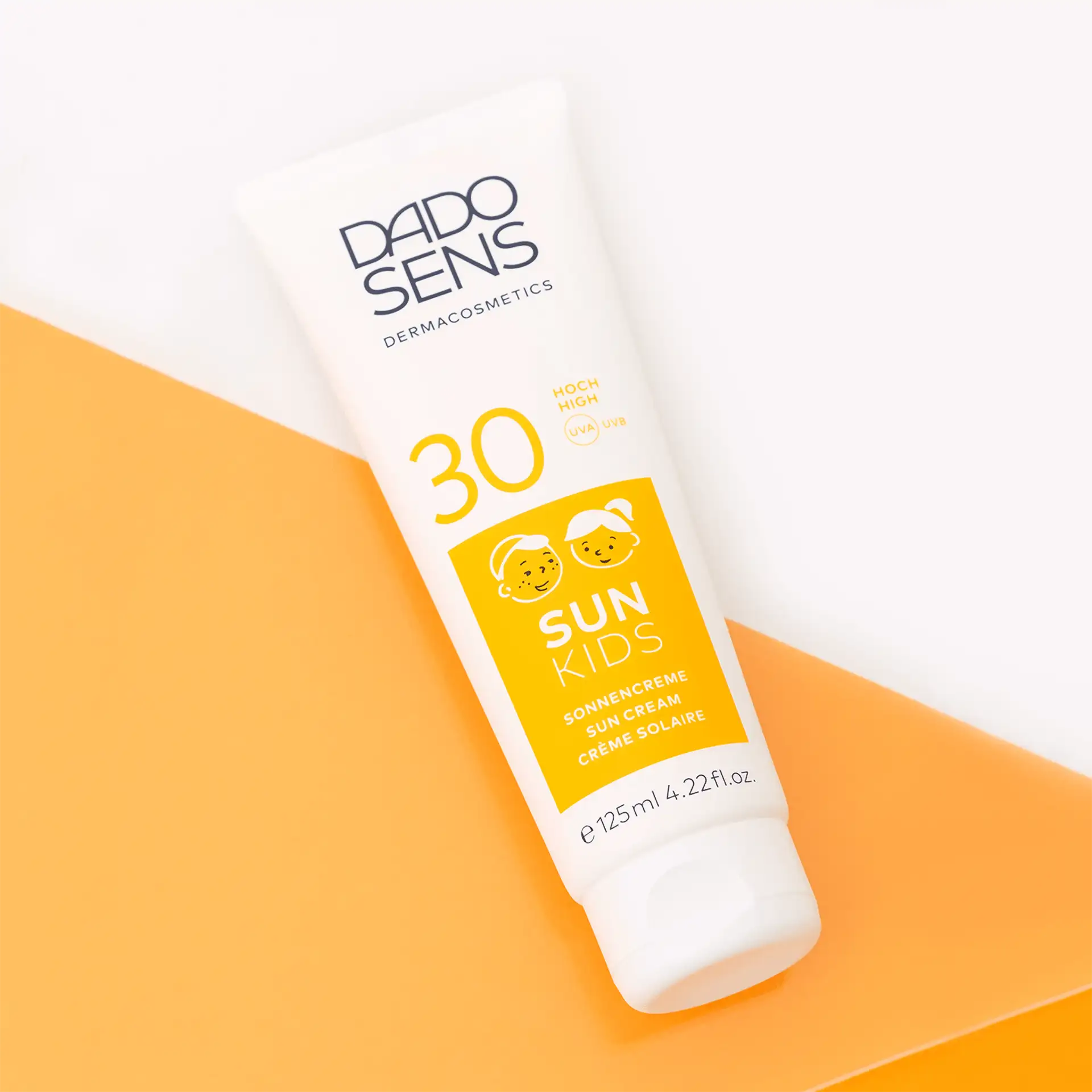 DADO SENS SUN KIDS Sonnencreme SPF 30 für Kinder, 125 ml, weiße Tube auf orange-weißem Hintergrund