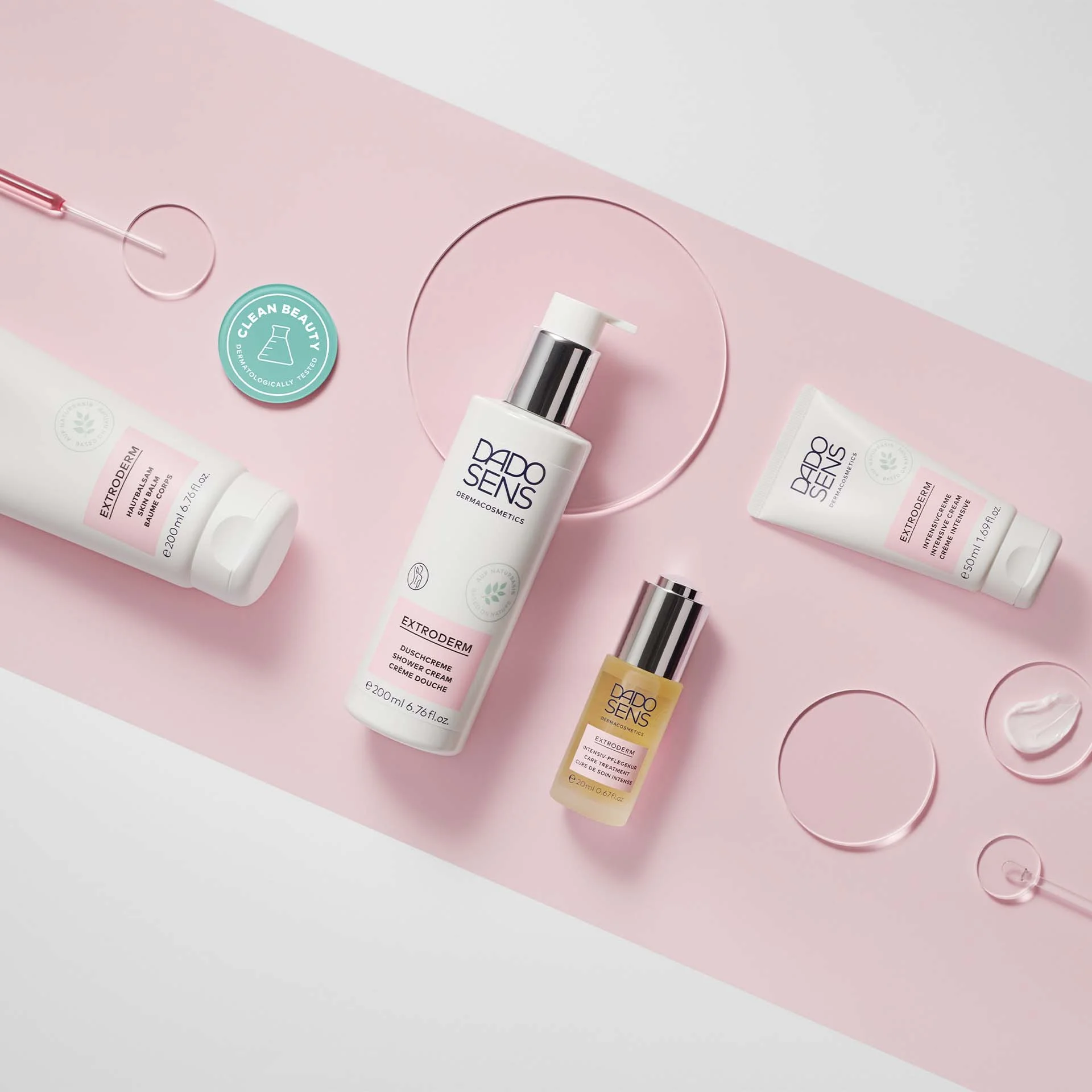 DADO SENS EXTRODERM Duschcreme, Intensivcreme, Hautbalsam und Intensiv-Pflegekur auf rosa Hintergrund