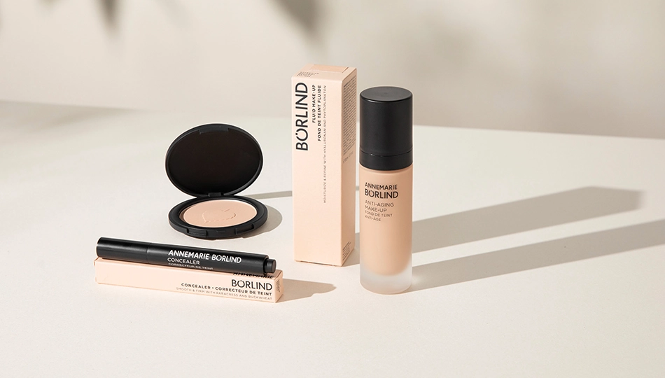 No-Make-up-Look ANNEMARIE BÖRLIND Anti-Aging Make-up, Concealer und Kompaktpuder mit Verpackungen auf hellem Untergrund