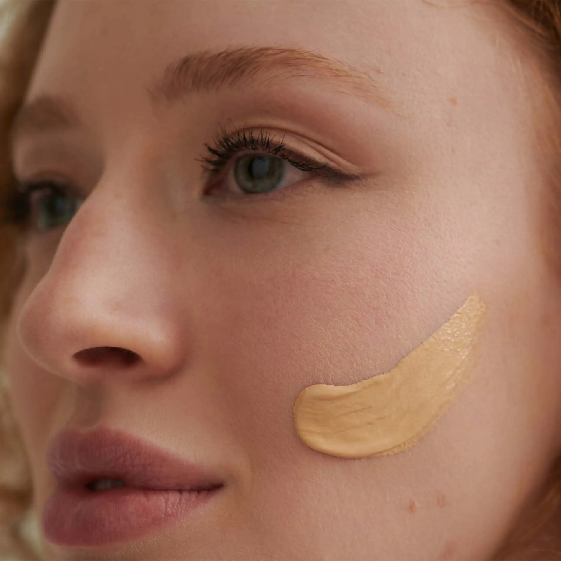 DADO SENS hypersensitives Make-up mit Mandel-Textur auf Wange eines Gesichts aufgetragen